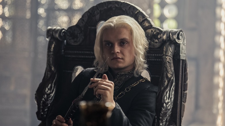 Aegon holding knife in chair