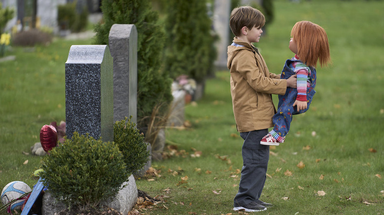 Henry Collins holding Chucky in graveyard