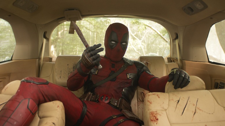 Deadpool lounging in a car