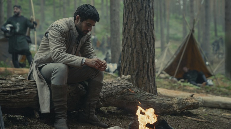 Ser Criston Cole tending a fire